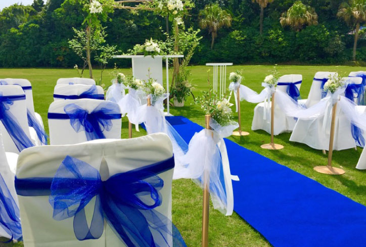 ホテル伊豆急のガーデン挙式会場の白い椅子と青いリボン